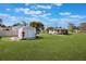 Large backyard with storage shed and covered porch, offering plenty of outdoor space for activities and storage at 5900 Lyle St, Orlando, FL 32807