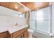Cozy bathroom featuring a wood-paneled ceiling, vanity with sink, and a shower-tub combo with sliding glass doors at 5900 Lyle St, Orlando, FL 32807