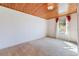 Well-lit bedroom with wooden paneled ceiling, neutral carpet, and a large window providing ample natural light at 5900 Lyle St, Orlando, FL 32807