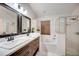Bathroom boasts double vanity, tub, and glass-enclosed shower for a luxurious feel at 611 Saddle Ridge Dr, Davenport, FL 33896