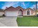 Charming single-Gathering home with a well-manicured lawn, two-car garage, and lovely curb appeal at 611 Saddle Ridge Dr, Davenport, FL 33896