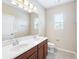 Bathroom featuring a double sink vanity, large mirror, and a toilet beneath a window at 7776 Rigby St, Windermere, FL 34786