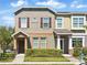 Charming townhome with neutral paint, brown shutters, and well-maintained front yard landscaping at 7776 Rigby St, Windermere, FL 34786