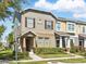 Inviting townhome with lush landscaping and a corner street sign at 7776 Rigby St, Windermere, FL 34786