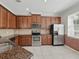 Well-lit kitchen boasts stainless steel appliances, granite countertops, and tiled backsplash at 7776 Rigby St, Windermere, FL 34786