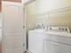 Laundry room featuring a washer and dryer set with an open doorway at 7776 Rigby St, Windermere, FL 34786