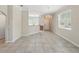 Open-concept living room with tile flooring, chandelier, and access to kitchen and front door at 7776 Rigby St, Windermere, FL 34786