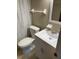 Bright bathroom featuring a toilet, vanity with sink, framed mirror and neutral colored walls at 913 Jacaranda Dr, Lady Lake, FL 32159