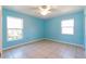 Bright bedroom featuring tile floors, ceiling fan, and two windows letting in natural light at 913 Jacaranda Dr, Lady Lake, FL 32159