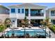 Inviting backyard featuring a sparkling pool, patio furniture, and lush tropical landscaping at 942 Jack Nicklaus Ct, Kissimmee, FL 34747