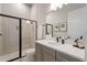 Stylish bathroom featuring gray vanity, black fixtures, and glass shower with neutral tile surround at 942 Jack Nicklaus Ct, Kissimmee, FL 34747