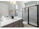 Modern bathroom with a black-framed glass shower and gray vanity with white countertops at 942 Jack Nicklaus Ct, Kissimmee, FL 34747