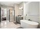 Modern bathroom featuring a glass shower, soaking tub, and double vanity with marble-look tile floors at 942 Jack Nicklaus Ct, Kissimmee, FL 34747