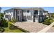 Beautiful two-story home featuring a modern facade, manicured landscaping, and a spacious brick driveway at 942 Jack Nicklaus Ct, Kissimmee, FL 34747