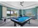 Spacious game room with a pool table and air hockey table with covered patio access at 942 Jack Nicklaus Ct, Kissimmee, FL 34747