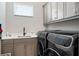 Well-organized laundry room with front-load washer/dryer, sink, and cabinet storage at 942 Jack Nicklaus Ct, Kissimmee, FL 34747