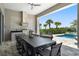 Outdoor dining with modern table and chairs overlooking the pool and tropical landscaping at 942 Jack Nicklaus Ct, Kissimmee, FL 34747