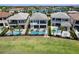 Stunning backyard view of modern homes with private pools and lush green landscaping overlooking a serene lake at 942 Jack Nicklaus Ct, Kissimmee, FL 34747