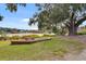 Scenic view of a community park with a lake, picnic tables, and a large oak tree draped with Spanish moss at 1118 Eagles Pass Way, Winter Garden, FL 34787