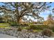 Community park featuring a dry creek bed with rocks, a lake, and oak trees draped with Spanish moss at 1118 Eagles Pass Way, Winter Garden, FL 34787