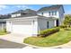 View of the detached two-car garage with white siding and manicured landscaping at 1118 Eagles Pass Way, Winter Garden, FL 34787