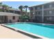 Community pool with a clear blue water, surrounded by lounge chairs, palm trees and residential buildings at 120 Blue Point Way # 360, Altamonte Springs, FL 32701