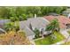 Aerial view of a home with a lush landscaped yard, mature trees, and a well-maintained gray roof at 13325 Falcon Pointe Dr, Orlando, FL 32837