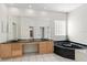 This luxurious bathroom boasts double sinks, an oversized mirror, a jetted tub, and natural light from a glass block window at 13325 Falcon Pointe Dr, Orlando, FL 32837