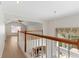 An upstairs hallway overlooks the stairs and downstairs kitchen and Gathering room, with hardwood floors throughout at 13325 Falcon Pointe Dr, Orlando, FL 32837