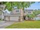 Charming two-story home with well-maintained lawn, stone accents, and a two-car garage at 13812 Magnolia Glen Cir, Orlando, FL 32828