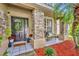 Inviting front porch with stone pillars, decorative wreath, and a cozy seating area at 13812 Magnolia Glen Cir, Orlando, FL 32828