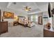 Large main bedroom with a tray ceiling, ceiling fan, large bed and two side tables at 13812 Magnolia Glen Cir, Orlando, FL 32828