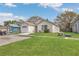 A charming single-story home featuring an attached garage and a lush green lawn at 1525 Rivers Edge Dr, Orlando, FL 32825