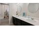 Well-lit bathroom with double sinks, modern faucets, dark cabinets, and a shower-tub combo with a decorative curtain at 15926 Marina Bay Dr, Winter Garden, FL 34787