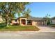 Inviting single-story home featuring a well-manicured lawn, a brick driveway, and a bright red front door at 1924 Eloise Cove Dr, Winter Haven, FL 33884