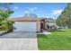 Charming single-story home featuring a two-car garage, manicured lawn, and inviting front entrance at 2421 Hybrid Dr, Kissimmee, FL 34758