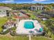 Aerial view of a private pool and tennis court surrounded by greenery and lush landscaping and parking at 2580 Grassy Point Dr # 100, Lake Mary, FL 32746