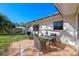 Back patio with table and chairs, surrounded by grass and mature tropical landscaping at 3006 Northwood Blvd, Winter Park, FL 32789