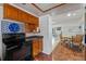 Cozy kitchen featuring black appliances, wood cabinets, and hardwood flooring with adjacent breakfast nook at 3006 Northwood Blvd, Winter Park, FL 32789