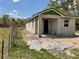 View of single story block home with lawn and blue skies, with installed door and window frames at 3027 Turkey Ave, Oviedo, FL 32765