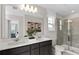 Modern bathroom with double vanity, neutral tile, and glass shower enclosure at 3371 Vine Leaf St, Apopka, FL 32712