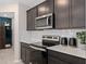 Well-equipped kitchen with dark wood cabinetry, quartz countertops, and modern stainless steel appliances at 3371 Vine Leaf St, Apopka, FL 32712