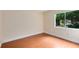 Bedroom with wood laminate flooring, light walls, and a bright window overlooking lush greenery at 3553 Jericho Dr, Casselberry, FL 32707