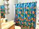 Blue-themed bathroom featuring a large shower with colorful fish curtain, and a sink with storage at 3810 Blue Dasher Dr, Kissimmee, FL 34744