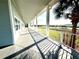 Covered porch with long walkway and white railing overlooks a grassy area near the water and a palm tree in the foreground at 3810 Blue Dasher Dr, Kissimmee, FL 34744