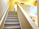 Carpeted stairs leading to the second story with a white banister and light-colored walls at 3810 Blue Dasher Dr, Kissimmee, FL 34744