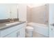 Well-lit bathroom featuring a vanity, toilet, and tiled shower-tub combination at 4032 Redbridge Loop, Davenport, FL 33837