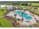 Inviting aerial view of the community pool area with lounge chairs, palm trees, and well-manicured grounds at 4086 Gooseberry Trl, Kissimmee, FL 34746