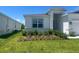 Well-maintained lawn, complemented by garden beds featuring shrubs, and a view of the home's front exterior at 4086 Gooseberry Trl, Kissimmee, FL 34746