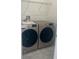 This laundry room features modern, front-load washer and dryer and overhead shelving at 4086 Gooseberry Trl, Kissimmee, FL 34746